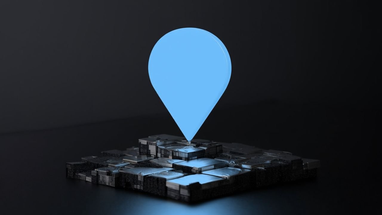 An ice-blue map pin glowing above a miniature silver street on a dark glossy surface.